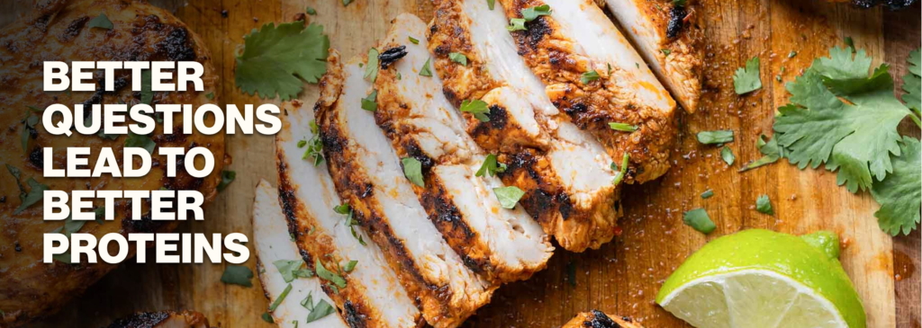 Sliced chicken on a wooden cutting board, sprinkled with cilantro and a lime.